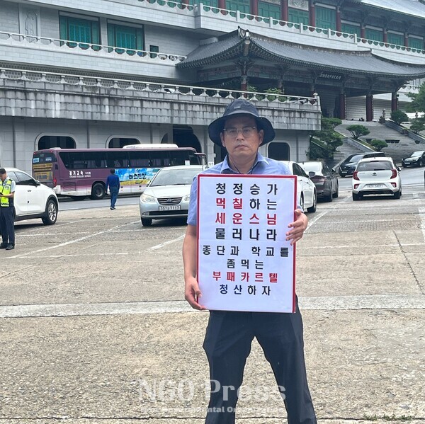 김찬우 금강대 전 총장직무대행이 규탄 피켓을 들고 서있다.